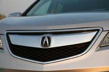 Автомобиль 2013 Acura RDX - вид спереди, эмблема Автомобиль 2013 Acura RDX - вид спереди, эмблема